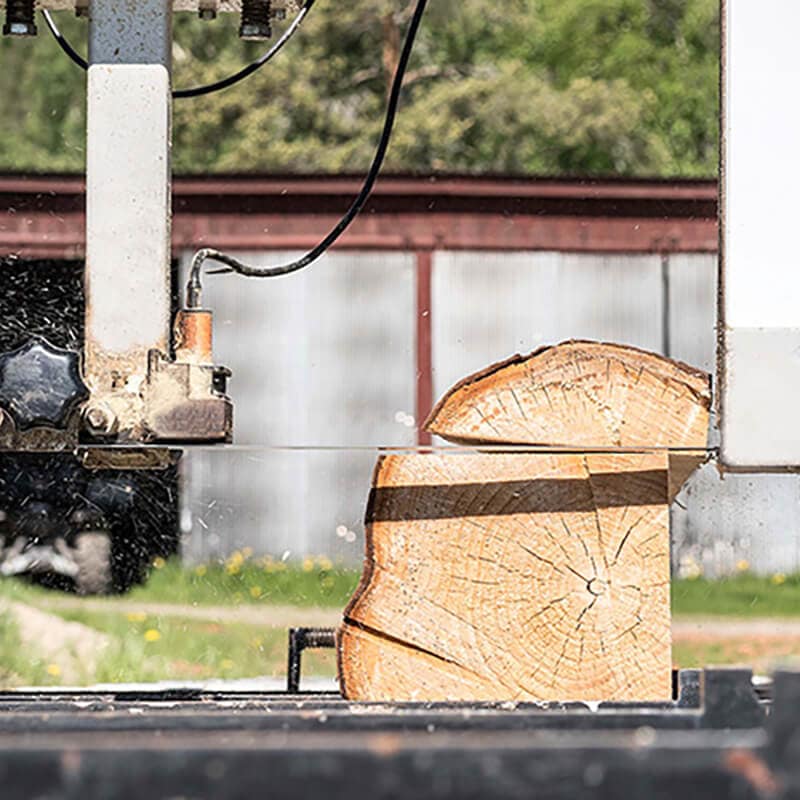 Sciage d'un billot de bois à l'aide d'un moulin portatif à l'extérieur